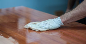 Person cleaning wooden table