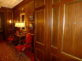 Wooden paneled hallway with red carpet