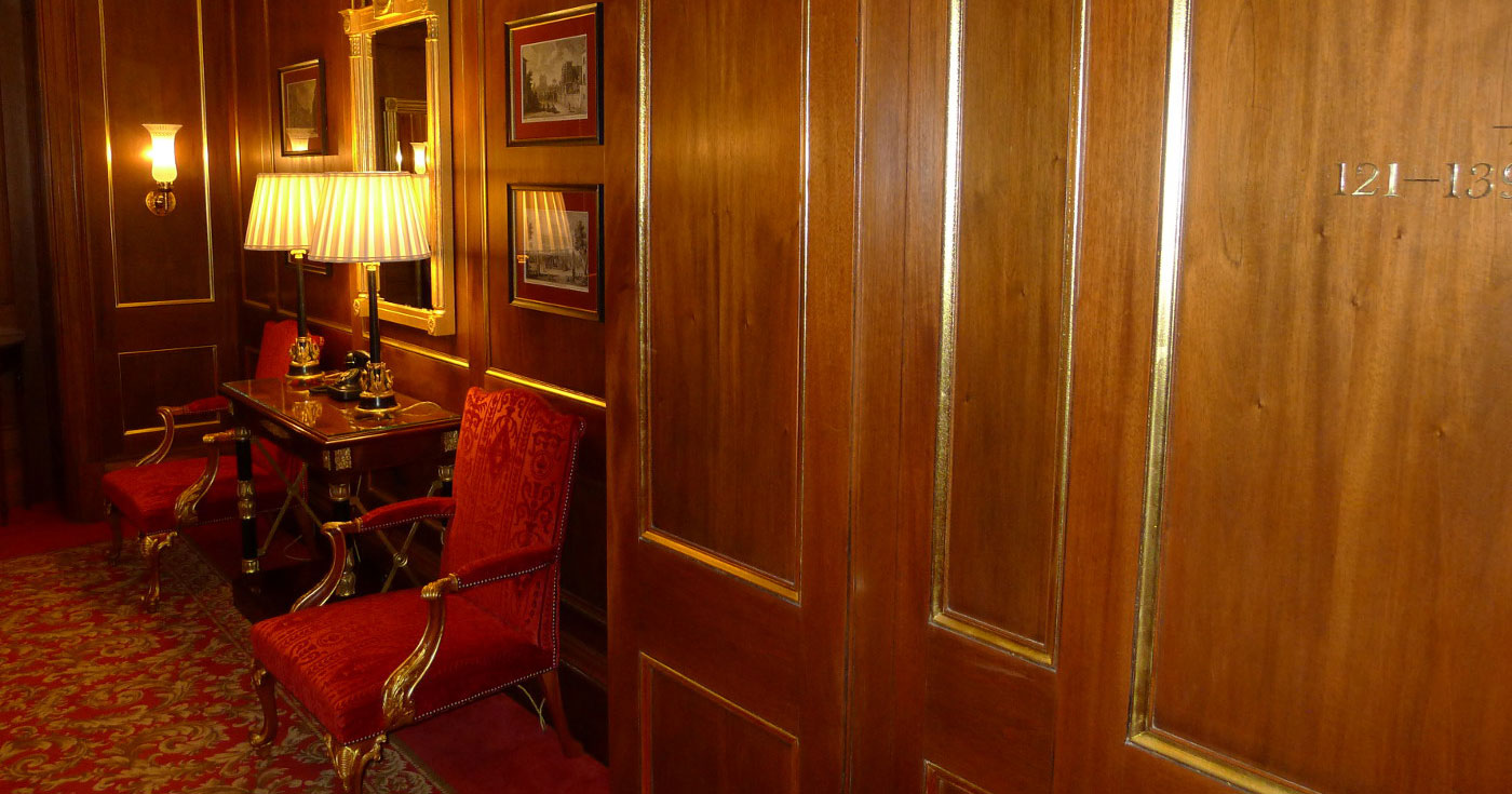Red chairs and table in hallway.